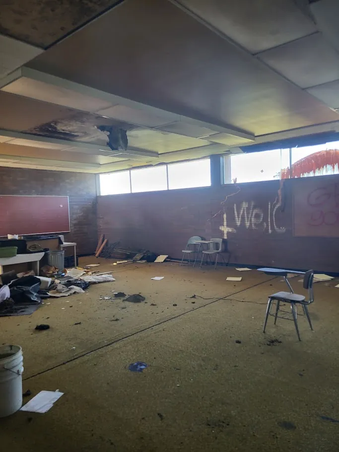 Current classroom with debris and damaged ceiling panels