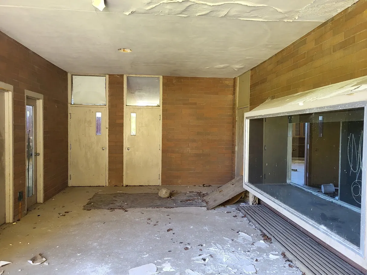 Current covered walkway showing peeling ceiling material and debris