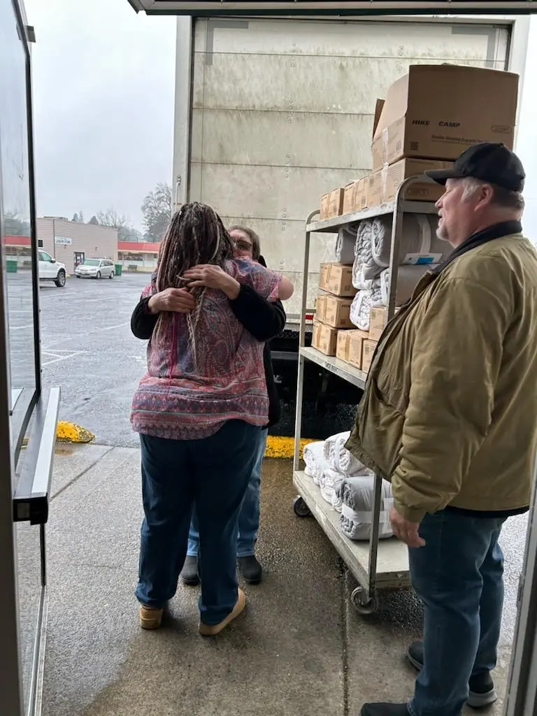 Angel Sheets embracing a community member near the GG's House truck