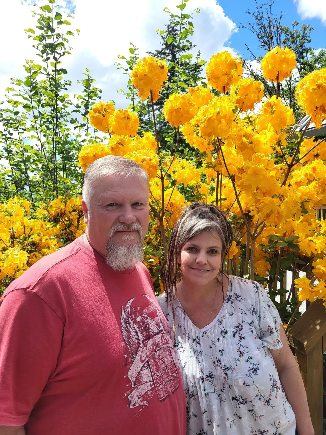 Steve and Angel Sheets standing together near yellow flowers