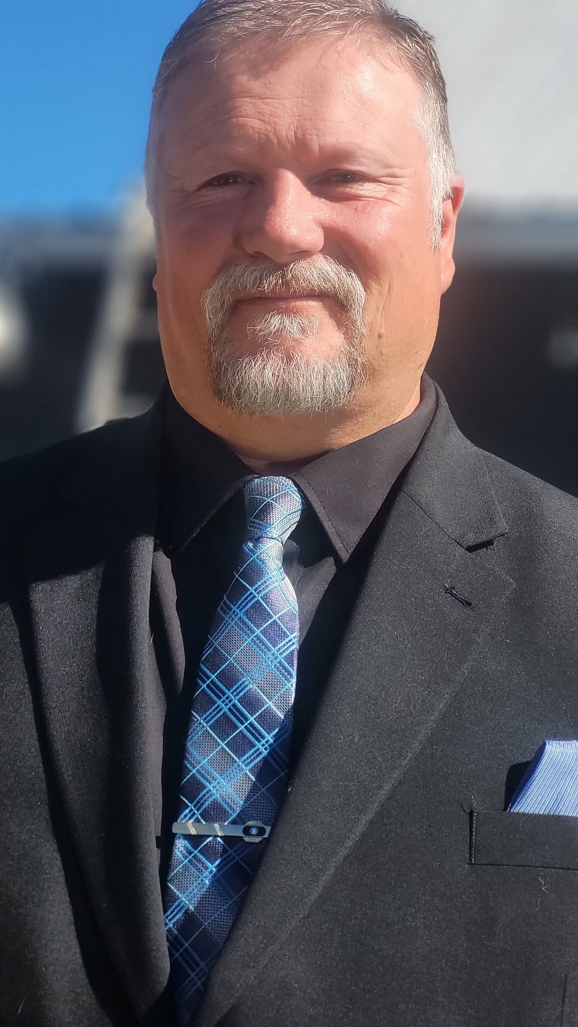Steve Sheets dressed in a suit and blue tie